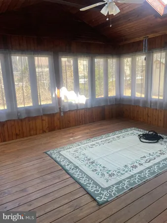 a view of a livingroom with wooden floor and a floor to ceiling window