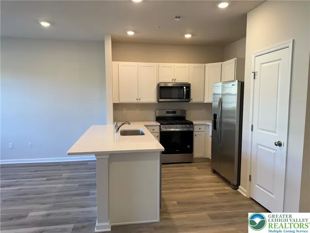 a kitchen with stainless steel appliances a refrigerator sink and microwave