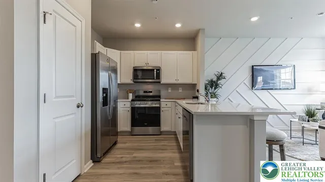 a kitchen with kitchen island stainless steel appliances a stove refrigerator sink and microwave