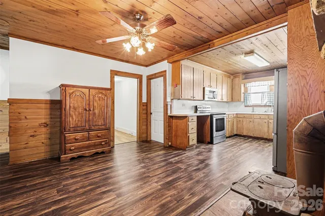 a kitchen with stainless steel appliances wooden floor and a refrigerator