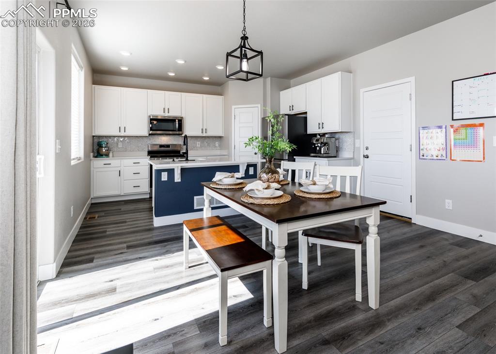12653 Granite Ridge Drive Peyton, CO 80831 - Photo 11 of 50 a kitchen with a table chairs refrigerator and microwave