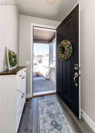 a hallway with wooden floor windows and a kitchen