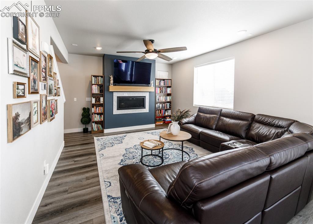 12653 Granite Ridge Drive Peyton, CO 80831 - Photo 7 of 50 a living room with furniture a fireplace and a flat screen tv