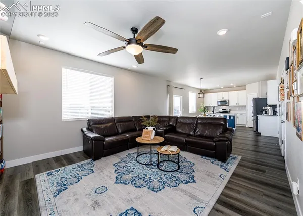 a kitchen with stainless steel appliances a dining table chairs stove refrigerator and cabinets