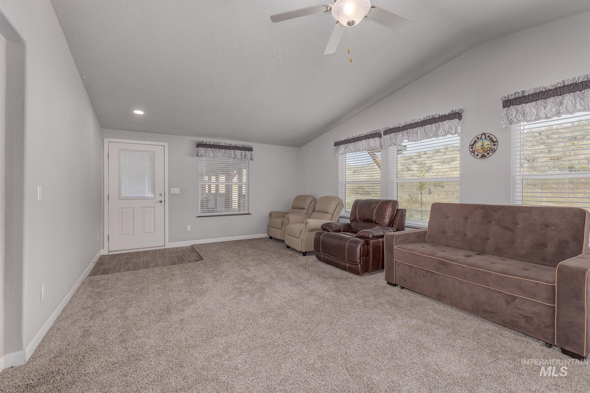 1587 Gentry Lane Weiser, ID 83672 - Photo 19 of 41 Carpeted living room featuring lofted ceiling and a ceiling fan