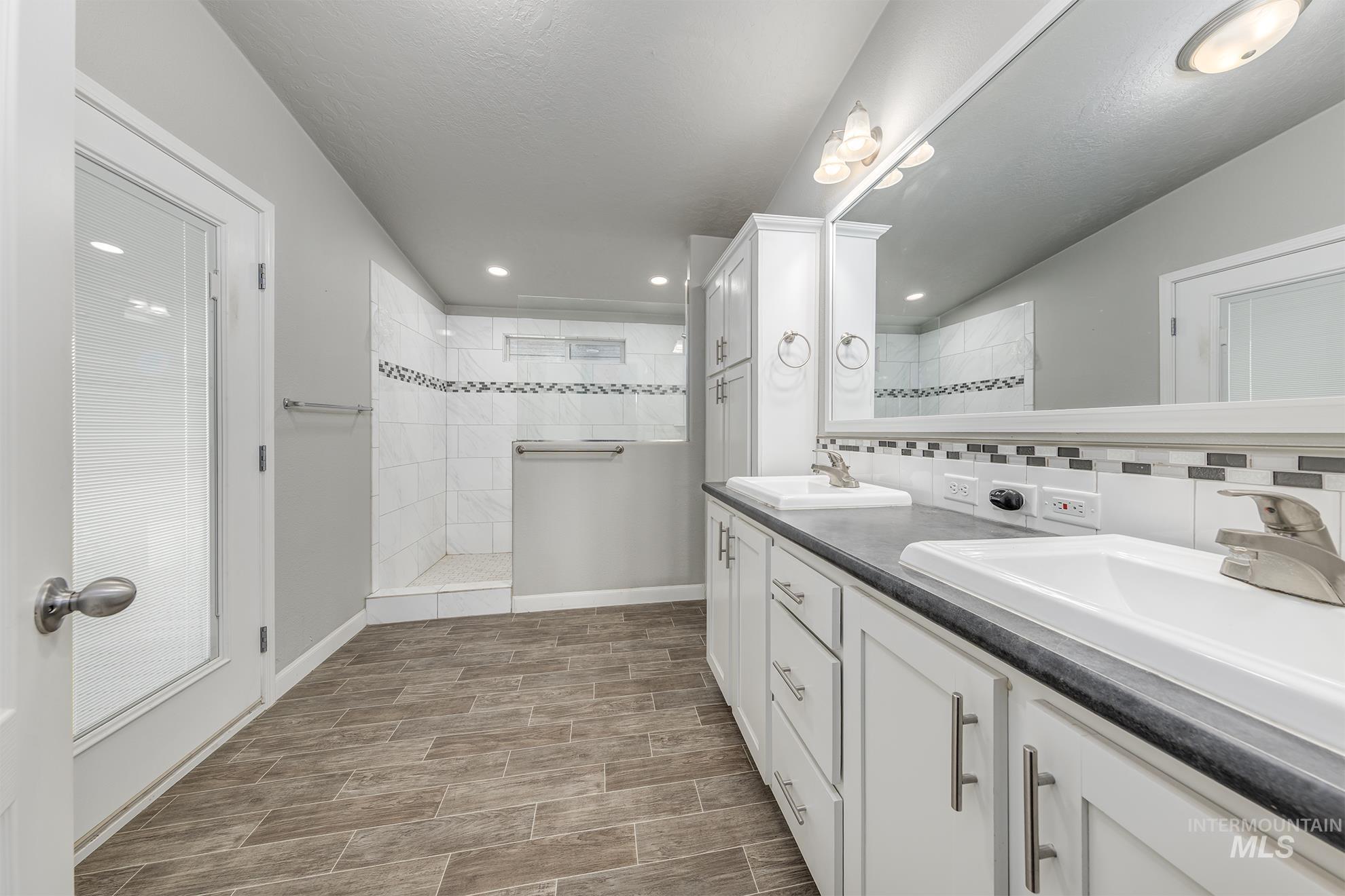 1587 Gentry Lane Weiser, ID 83672 - Photo 29 of 41 Full bath with a walk in shower, double vanity, recessed lighting, wood tiled floors, and tasteful backsplash
