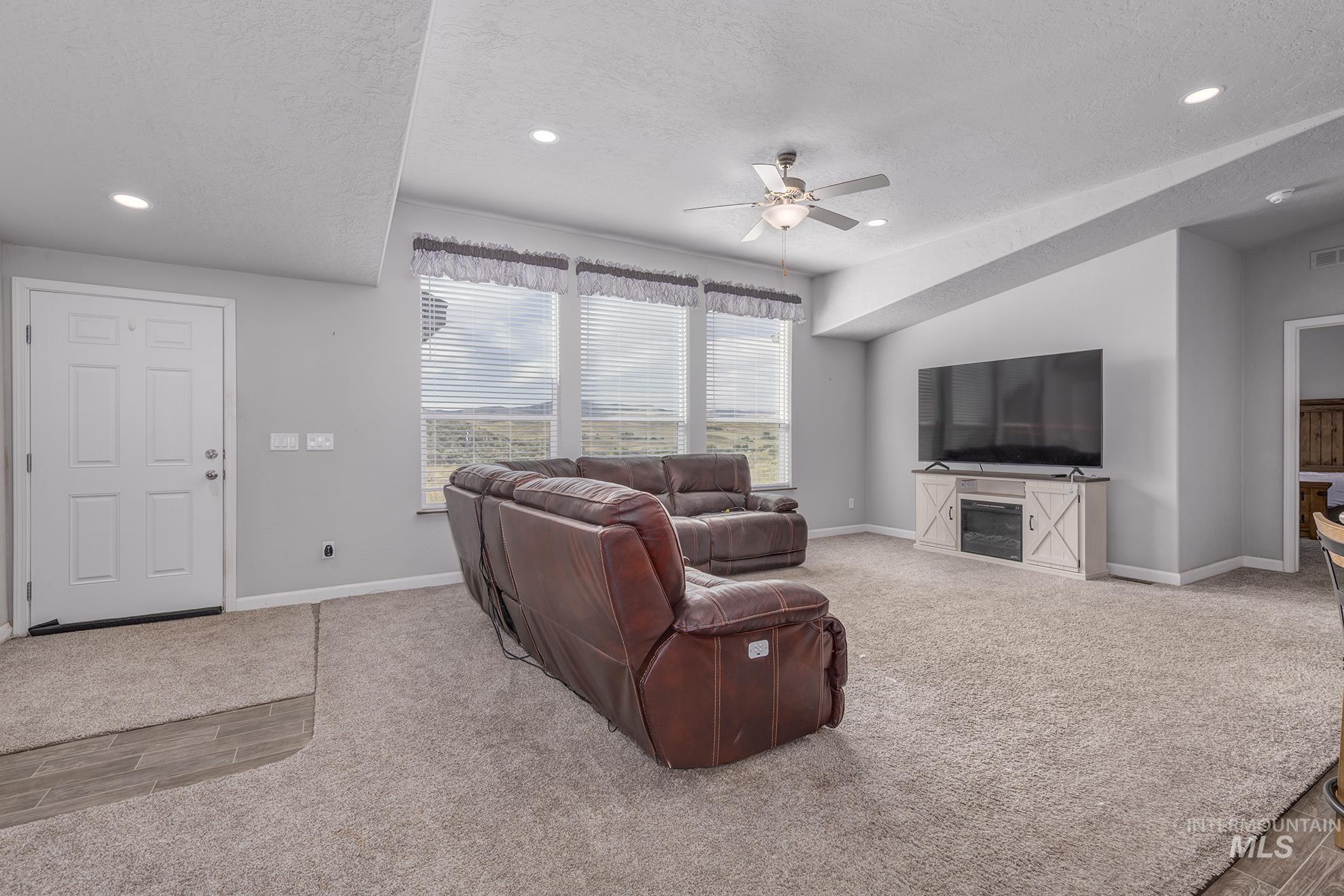 1587 Gentry Lane Weiser, ID 83672 - Photo 8 of 41 Living area featuring a textured ceiling, light carpet, recessed lighting, and ceiling fan