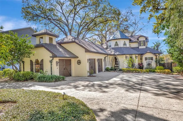 a front view of a house with a yard and potted plants