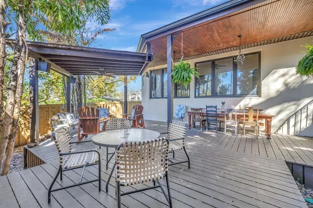 a view of a patio with table and chairs with wooden floor and fence