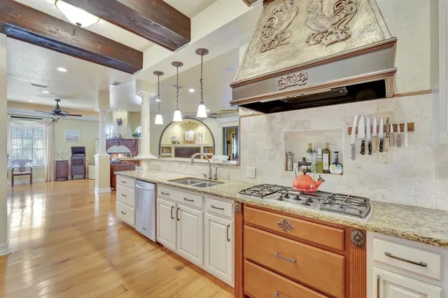 a kitchen with stainless steel appliances granite countertop a stove and cabinets