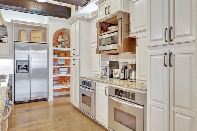 a kitchen with stainless steel appliances a refrigerator and a stove top oven