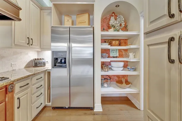 a kitchen with stainless steel appliances granite countertop a refrigerator and a cabinets