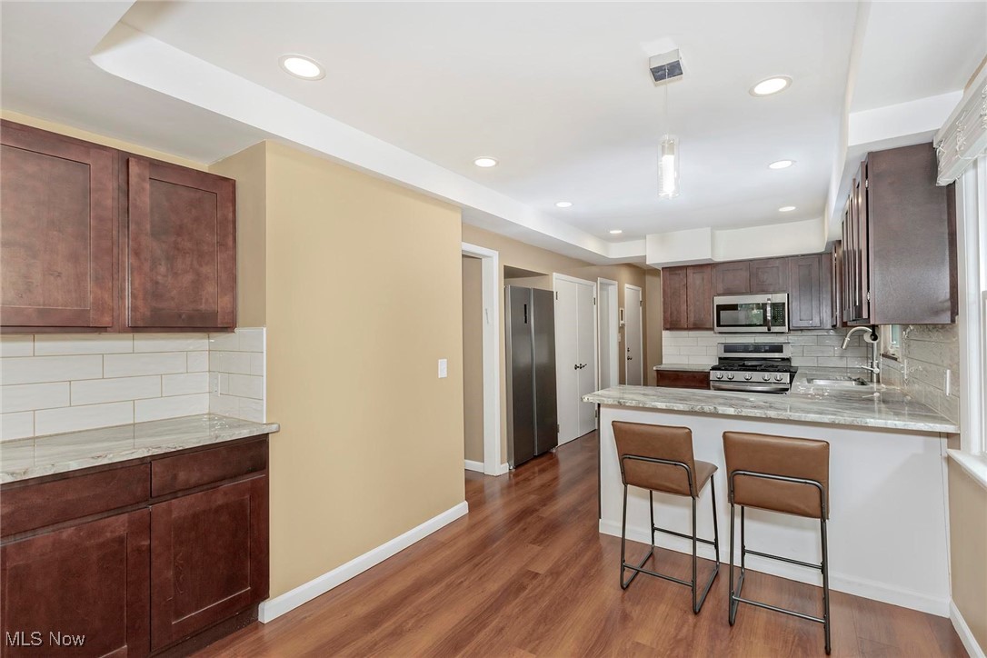 2381 Charney Road Cleveland, OH 44118 - Photo 6 of 47 Kitchen with stainless steel appliances, a sink, backsplash, a peninsula, and recessed lighting