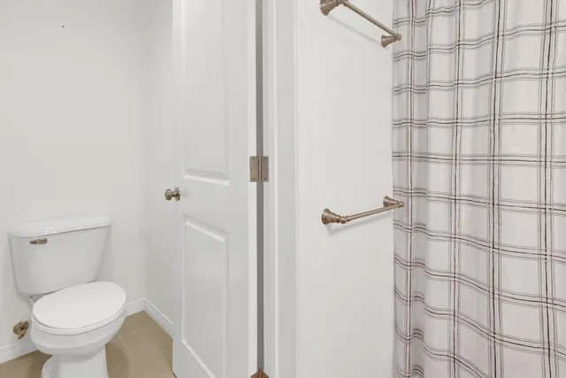 a bathroom with a toilet and a shower