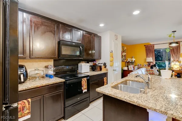 a kitchen with stainless steel appliances granite countertop a sink a stove and a microwave