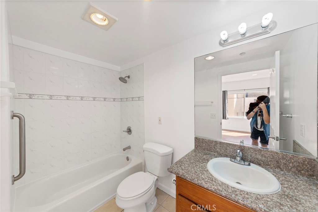 421 South Garfield Avenue, Unit 79 Monterey Park, CA 91754 - Photo 12 of 23 a bathroom with a granite countertop sink a mirror a toilet and shower