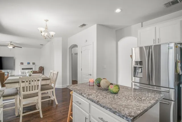 a kitchen with stainless steel appliances granite countertop a table chairs stove and refrigerator