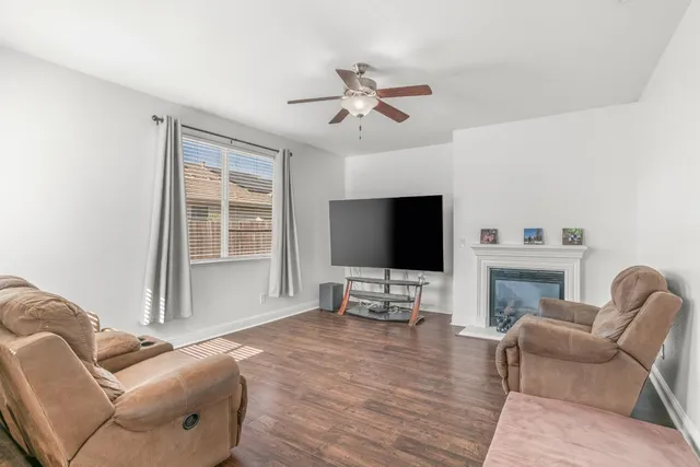 a living room with furniture a flat screen tv and a large window