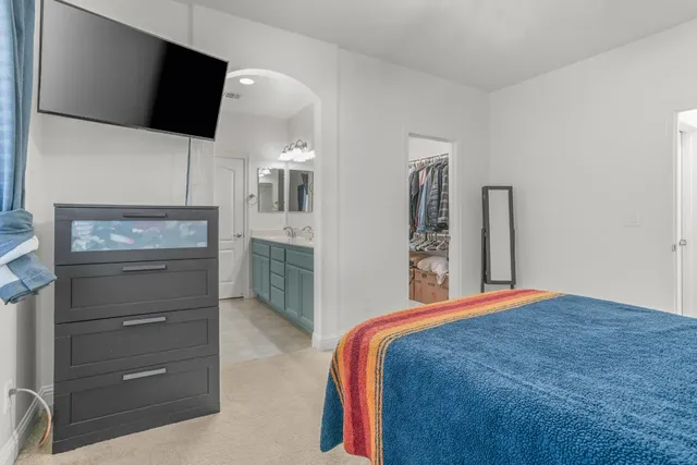 a bedroom with a bed and a flat screen tv