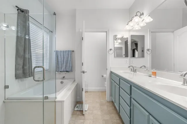a bathroom with a tub sink and mirror