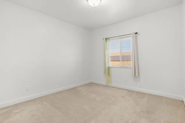 a view of backyard with seating space and wooden fence