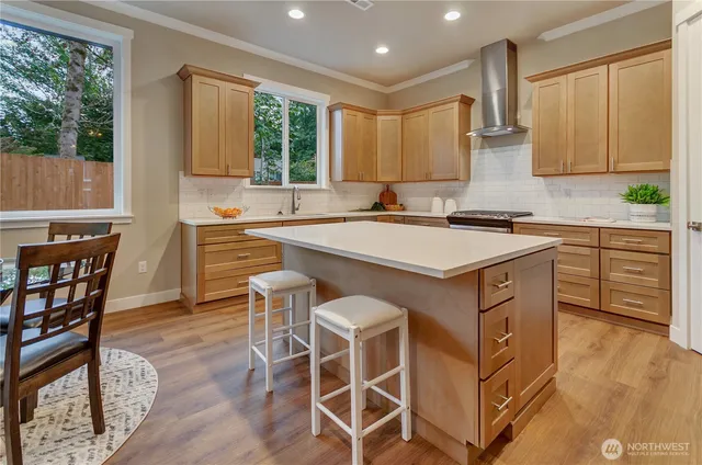 a kitchen with a stove a sink a dining table and chairs