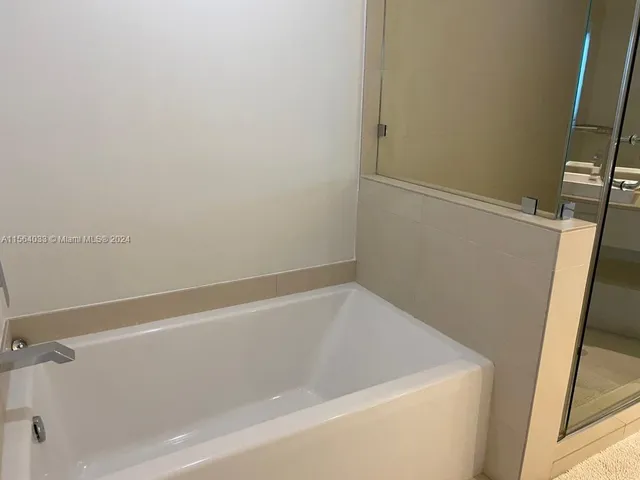 a bedroom with a bed and a lamp on dresser