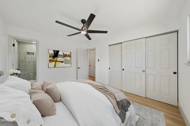 a bedroom with a large bed and a ceiling fan