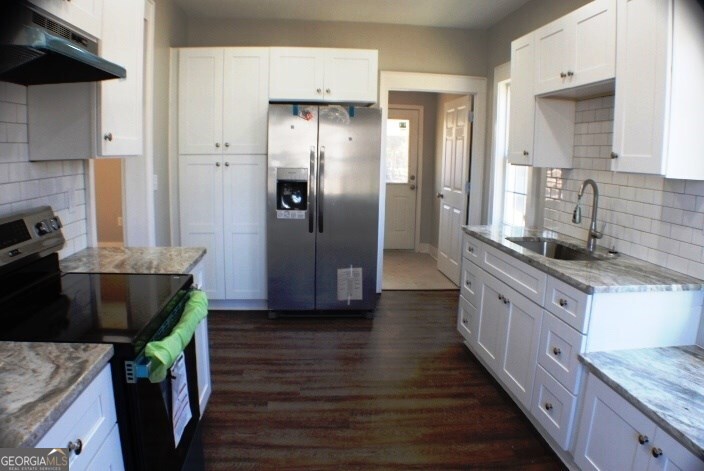 1007 Burch Street Cadwell, GA 31009 - Photo 12 of 25 a kitchen with stainless steel appliances granite countertop a refrigerator a stove and a wooden floors