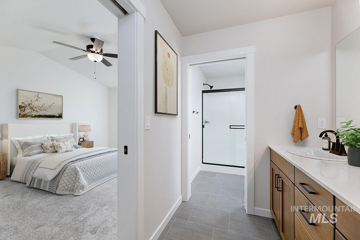 1700 East Hadler Street Meridian, ID 83642 - Photo 11 of 25 Bathroom featuring vanity, vaulted ceiling, a shower stall, dark carpet, and a ceiling fan