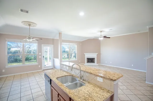 a kitchen with sink refrigerator and fireplace