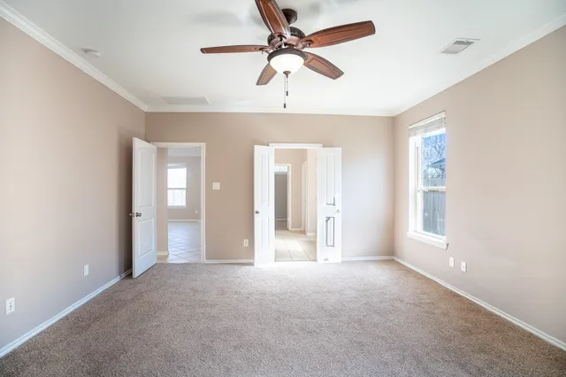 a view of a big room with windows and chandelier fan