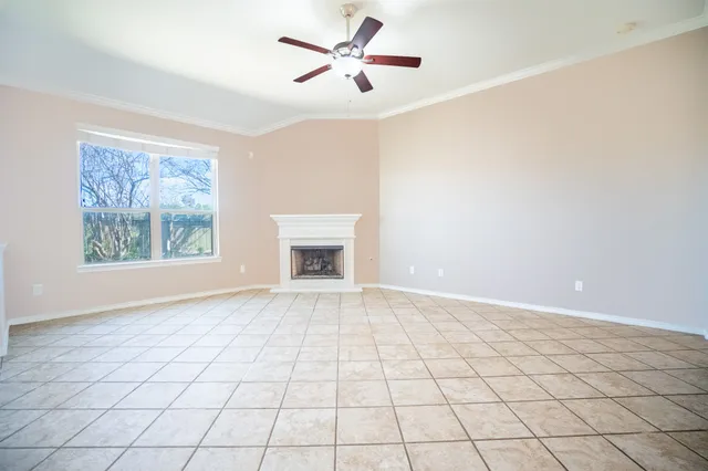 an empty room with windows and fan