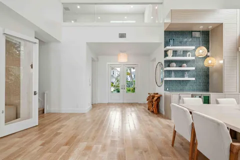 a view of a dining room with furniture a chandelier and wooden floor
