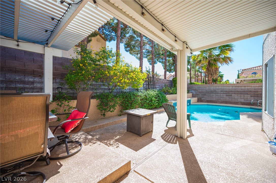 718 Rusty Spur Drive Henderson, NV 89014 - Photo 23 of 50 A tranquil outdoor living space featuring a refreshing pool and covered patio.