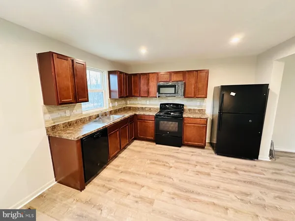 a kitchen with stainless steel appliances granite countertop a stove top oven and sink