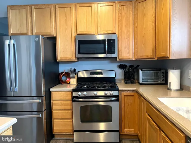 a kitchen with granite countertop a stove and a microwave