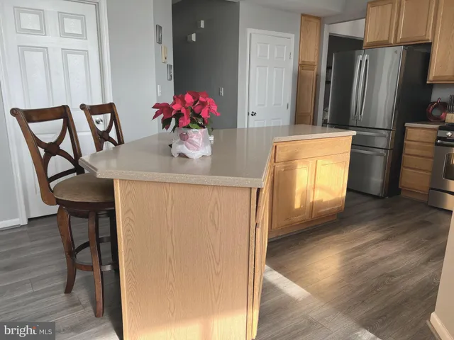 a kitchen with stainless steel appliances wooden cabinets and wooden floor