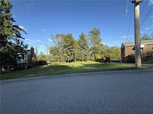 a view of a field with a house in the background