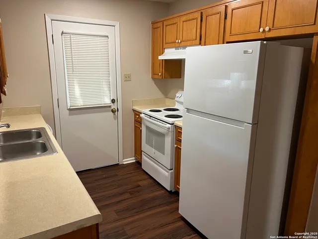 a white refrigerator freezer and a stove sitting inside of a kitchen