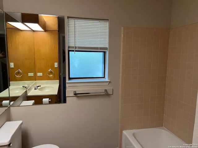 a bathroom with a toilet sink and mirror