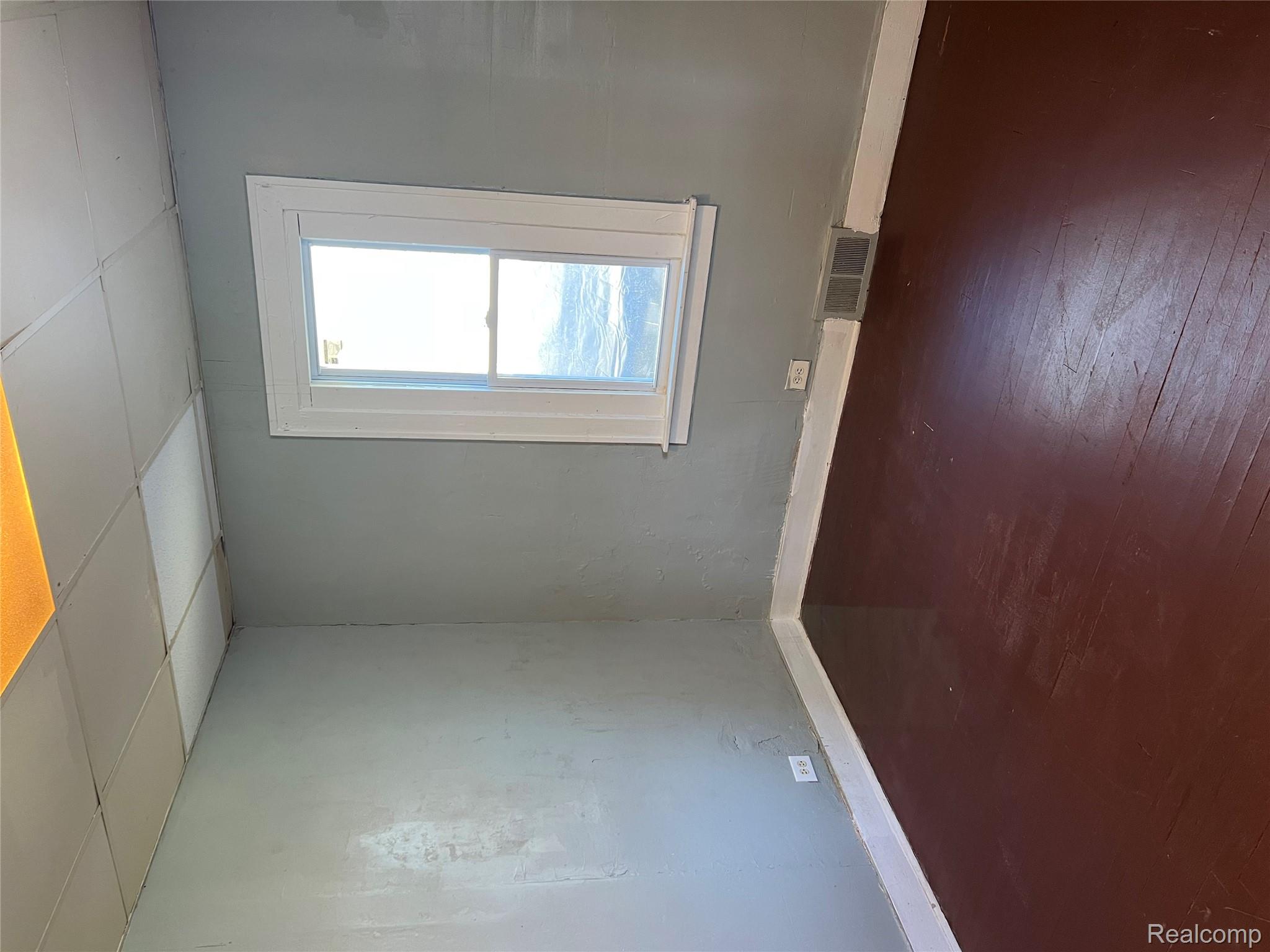 936 Stocker Avenue Flint, MI 48503 - Photo 4 of 15 Spare room with a drop ceiling and dark wood-type flooring