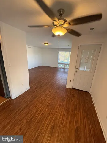 an empty room with wooden floor and chandelier