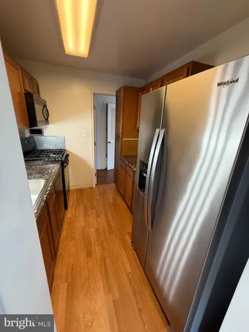 a view of a kitchen with wooden floor and electronic appliances