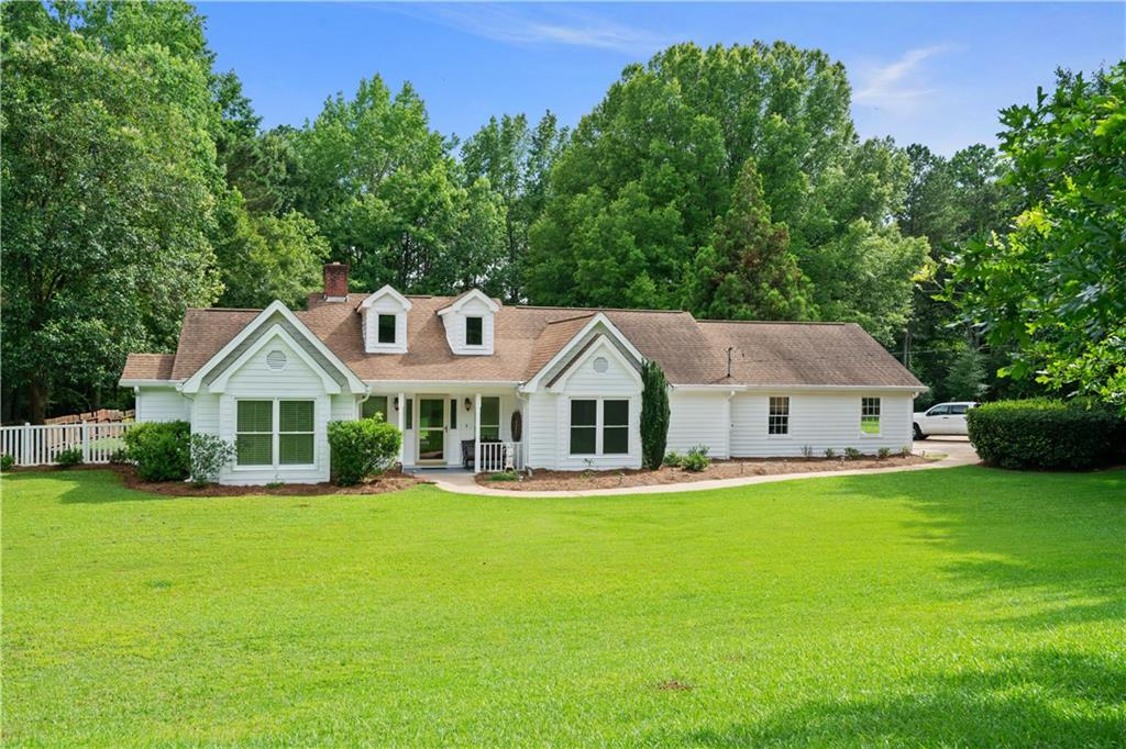 a front view of a house with a yard deck and large tree