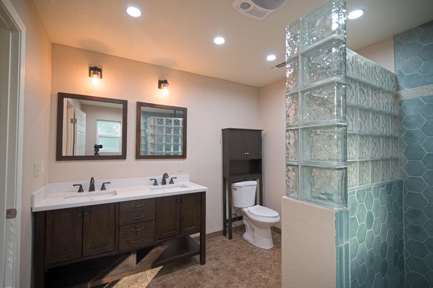 33072 Black Mountain Road Tollhouse, CA 93667 - Photo 21 of 45 a bathroom with a double vanity sink toilet mirror and shower