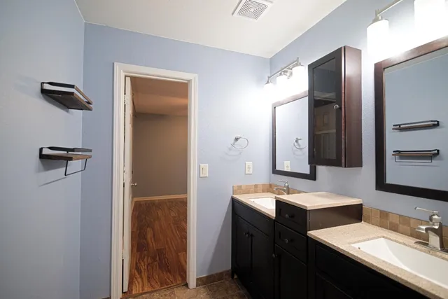 a bathroom with a double vanity sink a mirror and shower