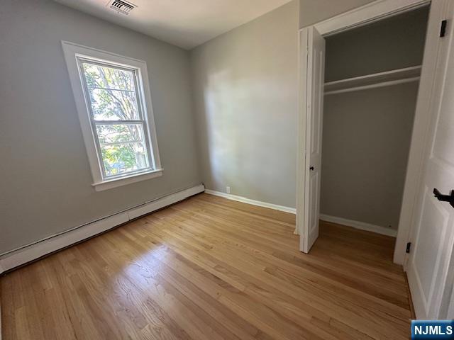 6 Pleasant Avenue, Unit 2 Clifton, NJ 07013 - Photo 11 of 14 an empty room with wooden floor closet and windows