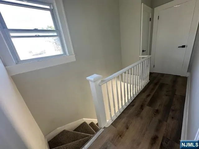 a view of a hallway with wooden floor and staircase