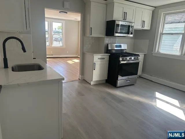 a kitchen with stainless steel appliances granite countertop a stove a sink dishwasher and a microwave